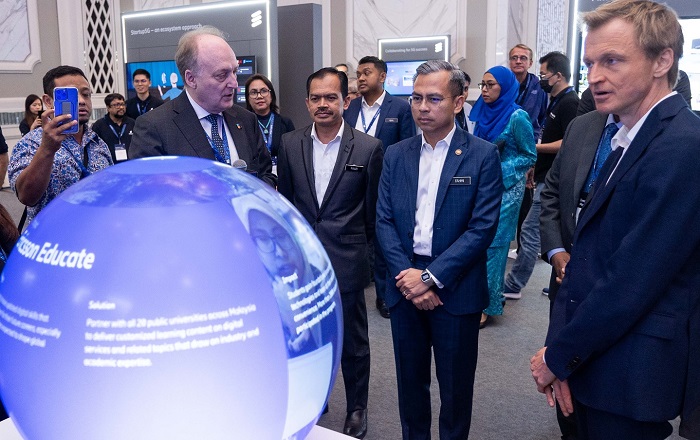 Dr. Magnus Ewerbring, CTO of APAC, Ericsson (left) briefing Fahmi Fadzil on Ericsson's Educate program where in Malaysia it is collaborating with MOHE, different higher learning institutions as well as MDEC. Looking on are Mohamad Fauzi Isa, Secretary-General, Ministry of Communications and Digital; and David Hägerbro (right), Head of Ericsson Malaysia, Sri Lanka and Bangladesh at the 5G exhibition booth.